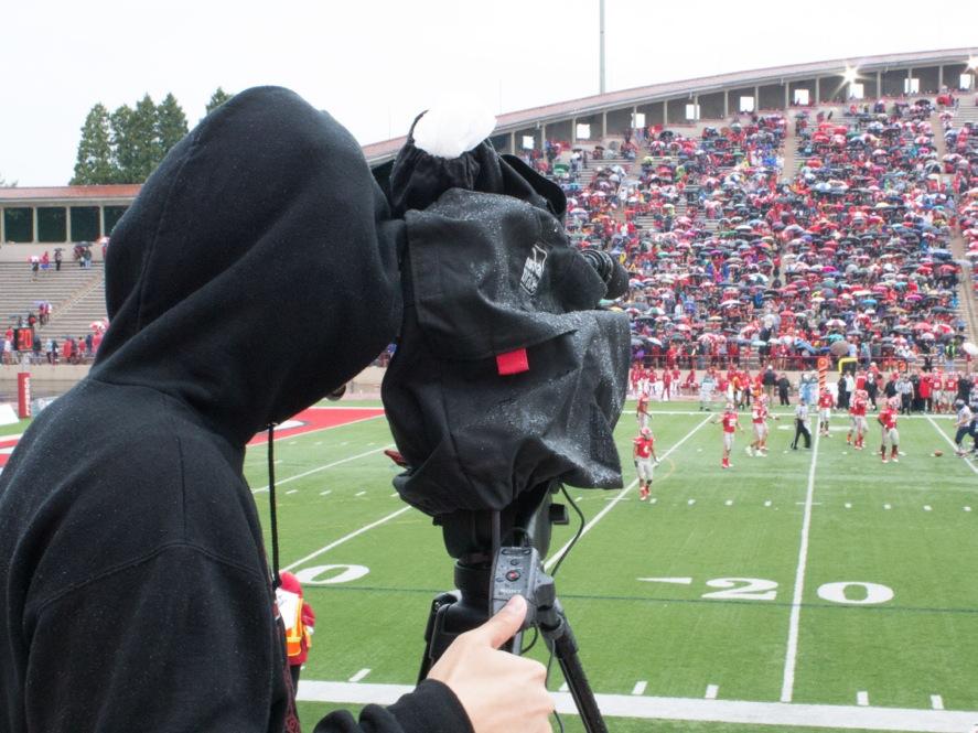 Cornell University student Shuo Cheng shoots video for the Ivy League Digital network at the Cornell homecoming football game.