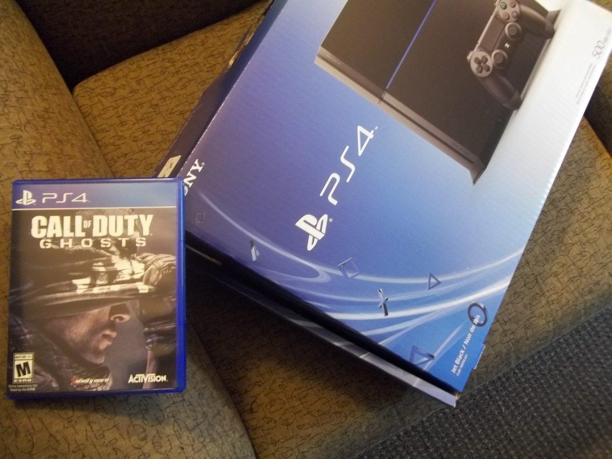 An unopened PlayStation 4 console and Call of Duty: Ghosts videogame sit, waiting to be played.