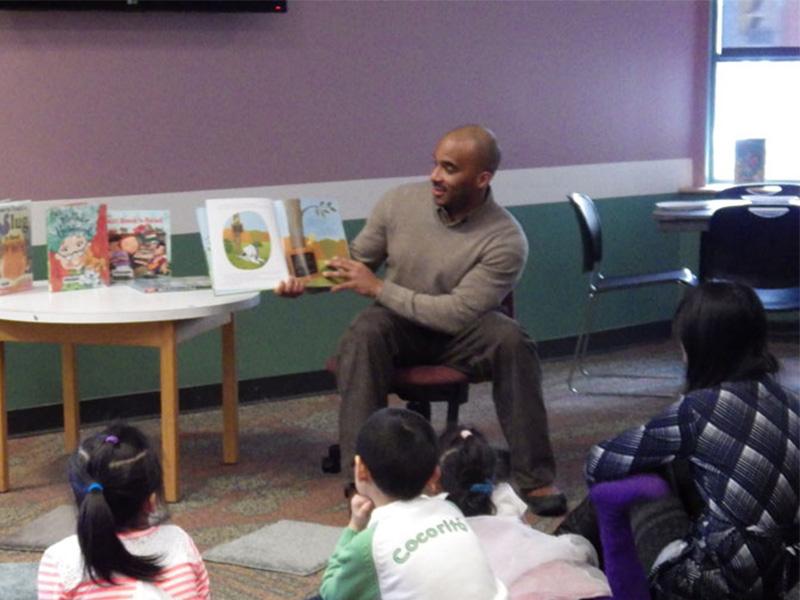 Luvelle Brown, superintendent of ICSD, reads to the children one of his favorite books at the first Ithaca Guys Read event. Photo courtesy of Tompkins County Public Library.