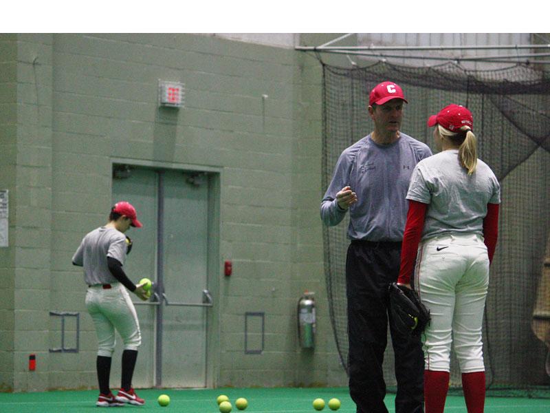 Cornell's head softball coach Dick Blood talks to a pitcher at practice at the Bartels Center.