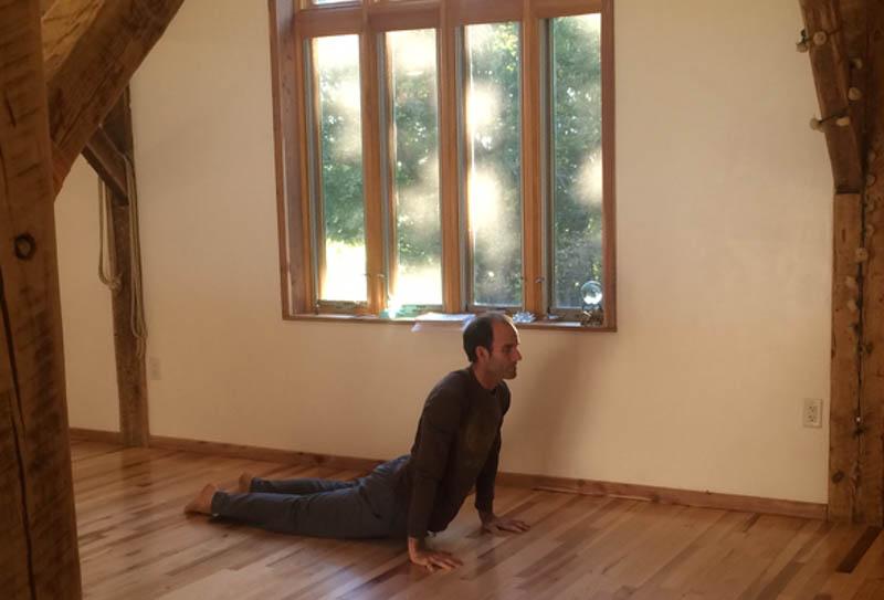 Christopher Grant, owner of the Yoga Farm, demonstrates a pose for a yoga class.