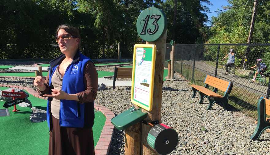 Director of Exhibits Donna DiBartolomeo explains the scientific elements of hole #13 at the Sciencenter’s new Mini-Golf course. 