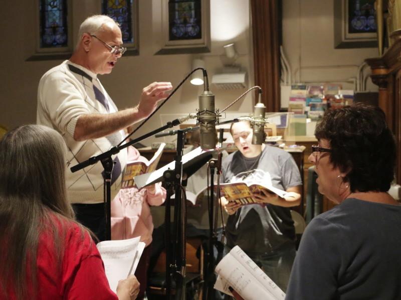 Gary Vrabel, the director of Immaculate Conception Church’s choir, conducts members during a song.
