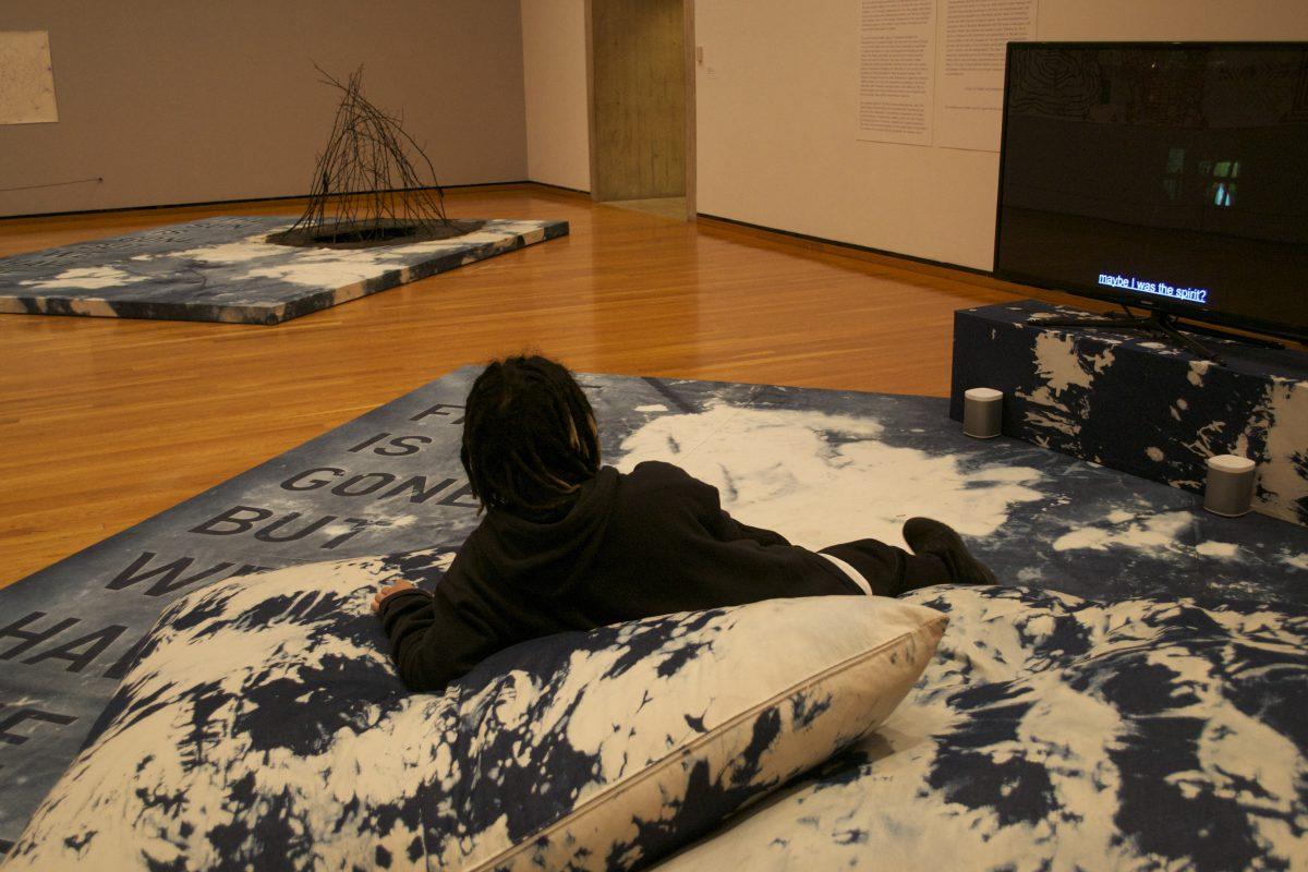 Korakrit Arunanondchai watches the video installation in his collaborative exhibition at the Johnson Museum of Art.
