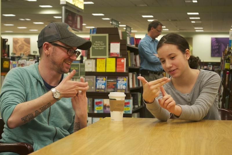 Joshua Bastian Cole, PhD student at Cornell University for Performing and Media Arts, and Aurora Golden Appleton, coordinator of ASLCI, practice communicating using ASL.