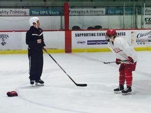 Team member with coach at their practice at Lynah Rink// Image by Lisbeth Perez