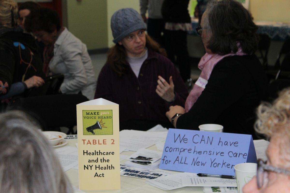 Susan Beckley interacting with member of the community as they have a question about the New York Health Act.