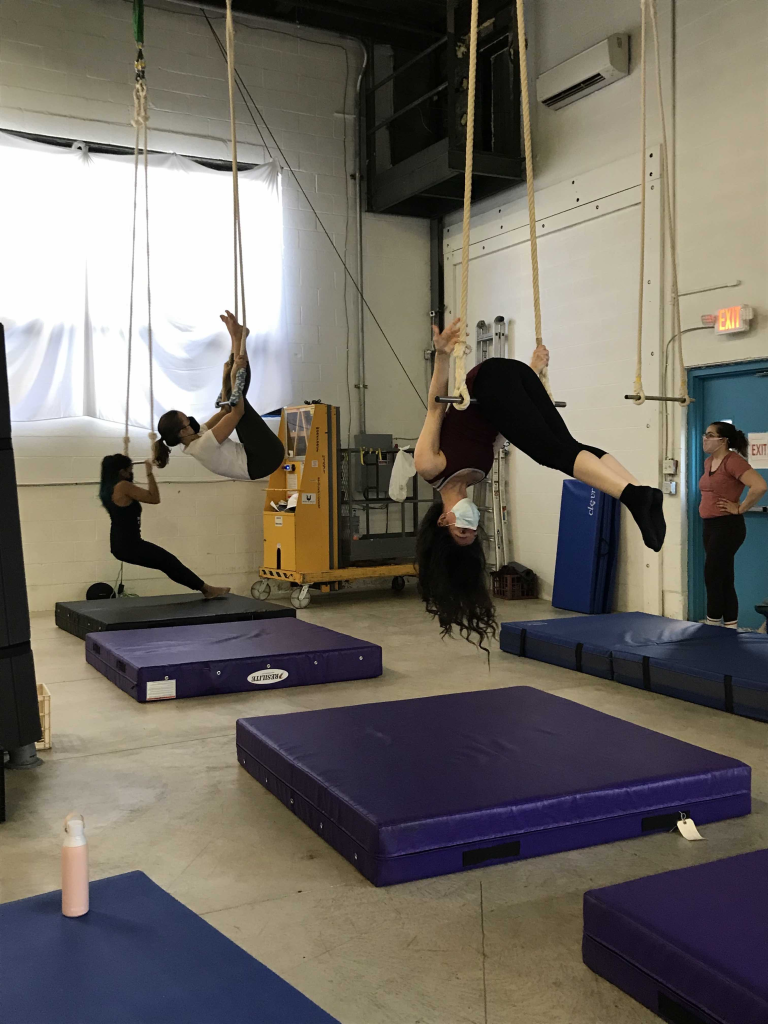 Students in Trpeze Level One at The Bird's Nest developing strength and working on a move. Strengthening has been a key aspect in classes that must avoid hands on spotting for now. Photo by Olivia King/Ithaca Week.