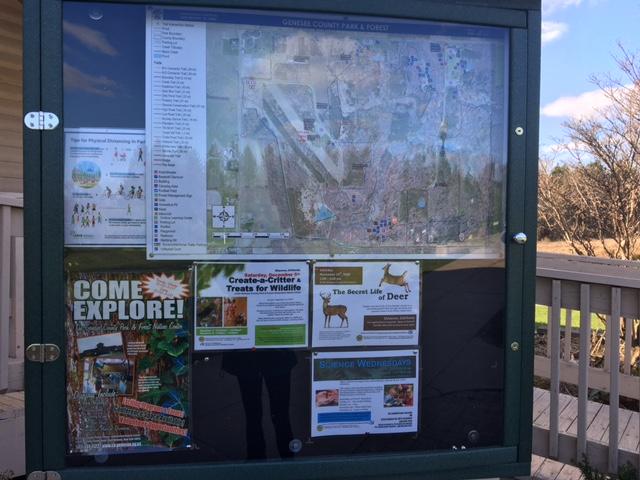 Park sign with map and event posters