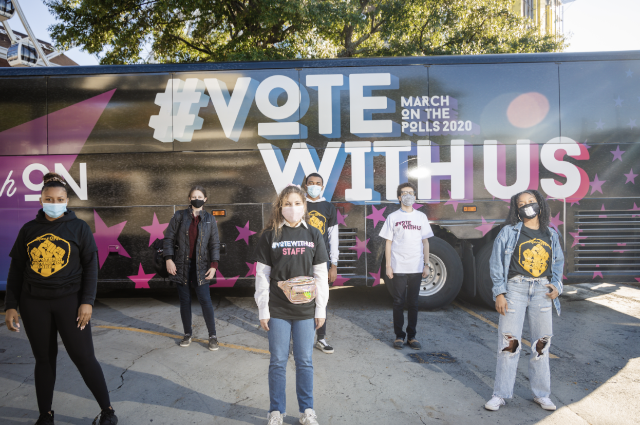 MarchOn organizers for the #VoteWithUs campaign stand in front of their tour bus in Atlanta, GA
