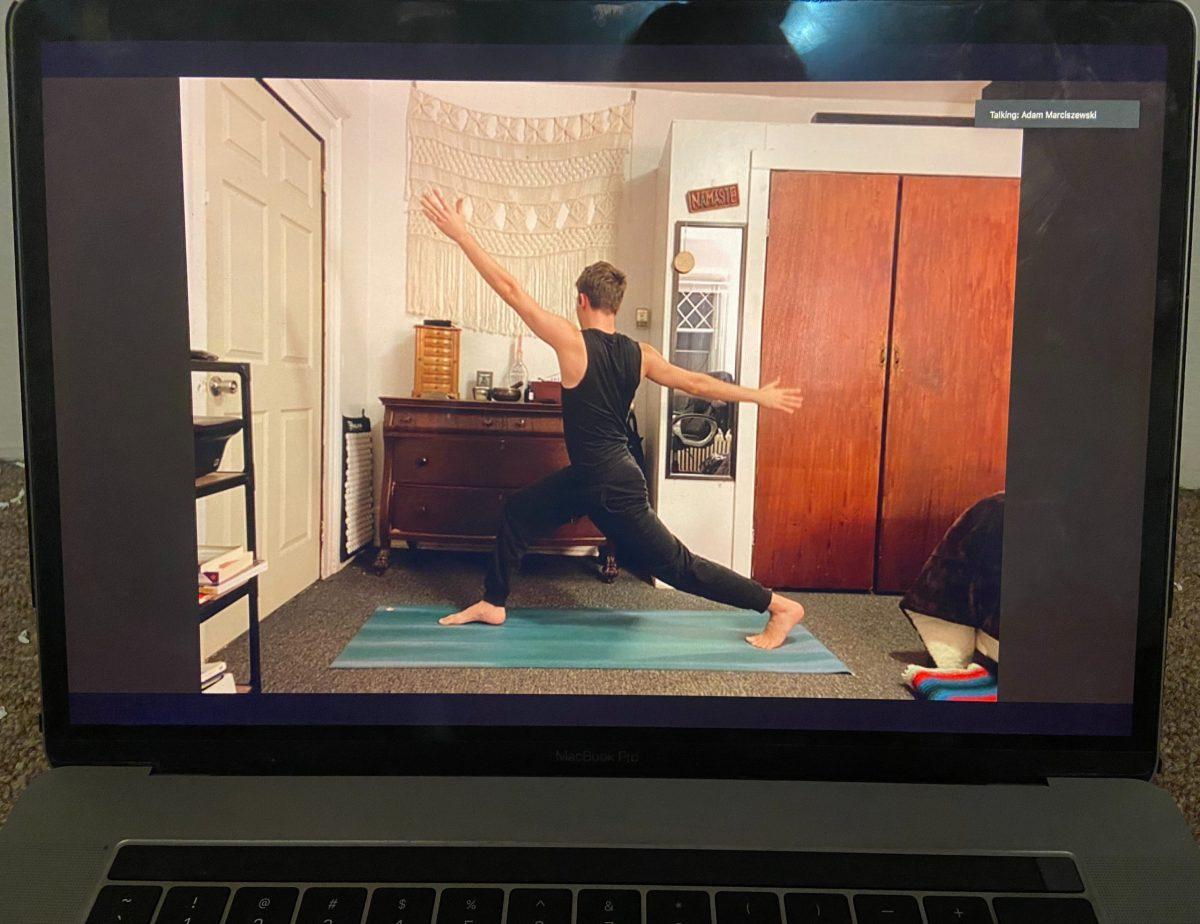 Junior Adam Marciszewski demonstrates a pose during the Vinyasa yoga class that he teaches weekly. Emily Adams/Ithaca Week