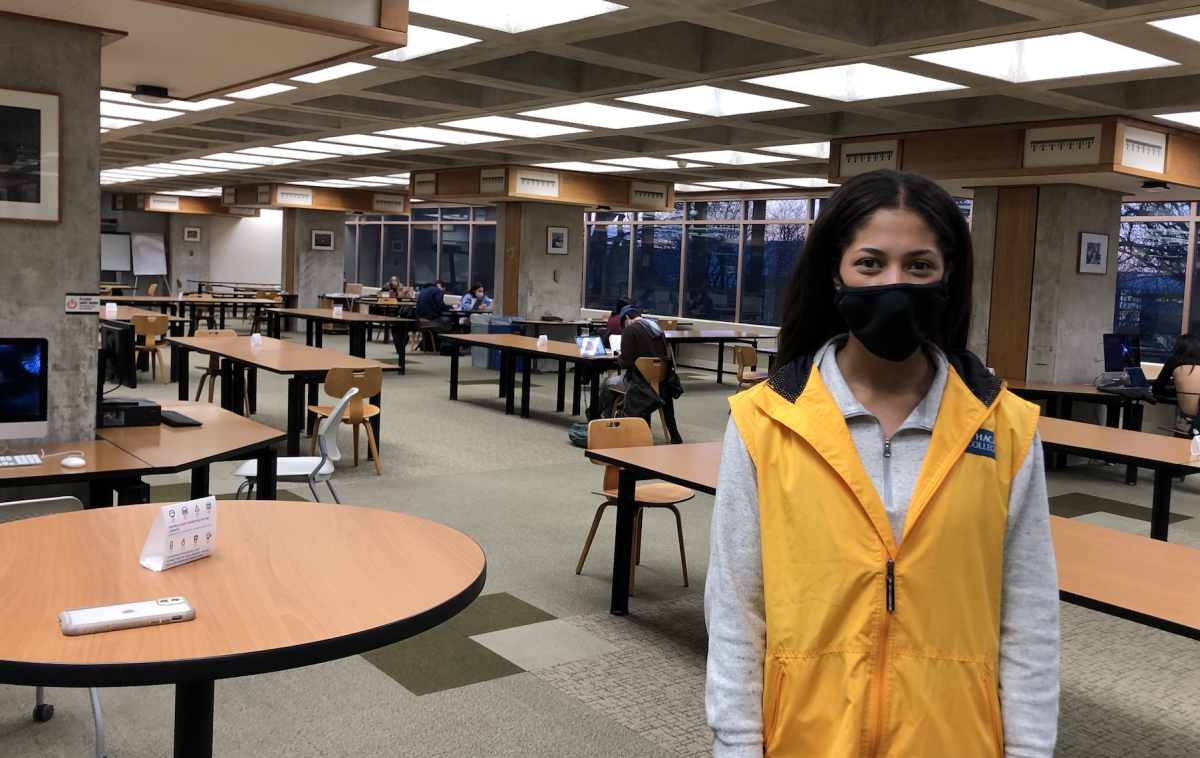 Senior Brina Edmonds-Reed wears her Public Health Ambassador vest while making rounds at the Ithaca College Library.

