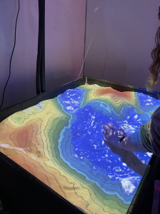 An interactive sandbox where the elevation map moves with where the sand is placed