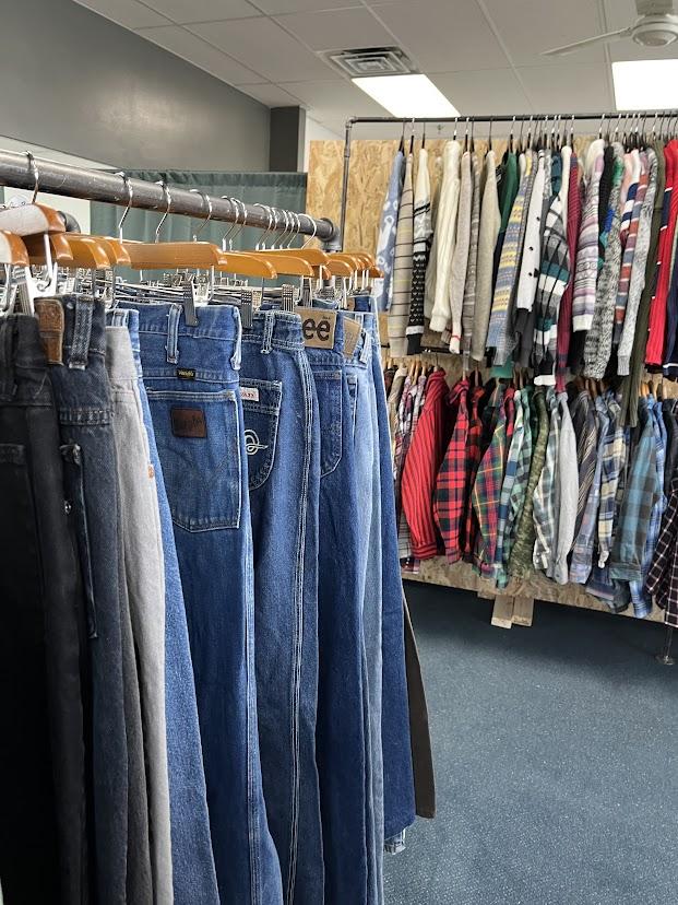Clothing racks with denim and longsleeve tops.
