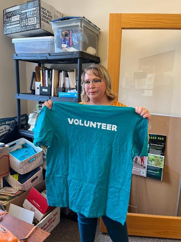 Alvstad-Mattson holding a tee shirt that they give volunteers, in preparation for an upcoming event.