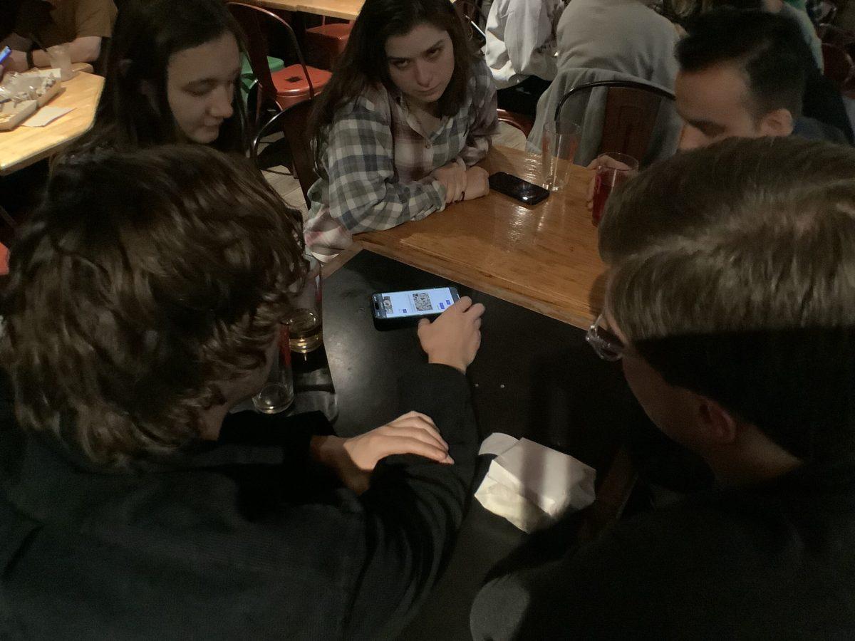 From left clockwise, Cornell University students Andrew Carpenter, Astoria Hall, Maureen Balcerzak, Rory Confino-Pinzon and Evan Greenberg work as a team to answer a trivia question. Elizabeth Kharabadze/Ithaca Week