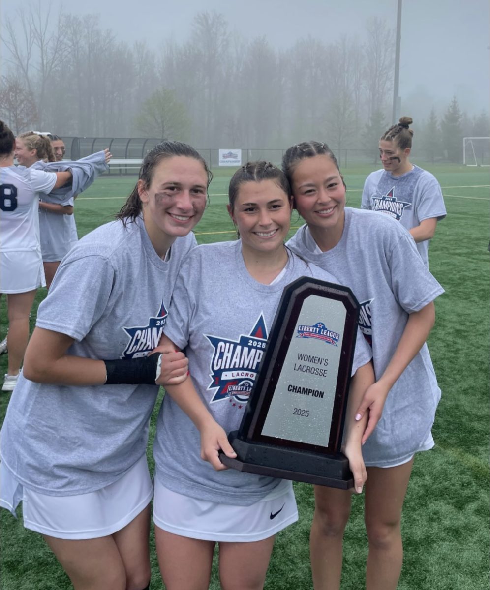 From left, Hosford, Cody, and Naturale holding their 2025 Liberty League Trophy.